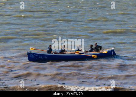 Pilote Gig course sur l'estuaire de la Severn avec une mer agitée Banque D'Images