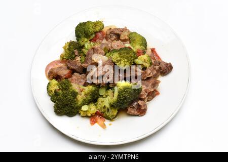 RAGOÛT DE BŒUF ET DE BROCOLI SUR UNE ASSIETTE BLANCHE Banque D'Images