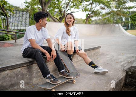 Un groupe d'amis s'amusant ensemble au Skate Park tout en faisant de l'équitation Skateboards Banque D'Images
