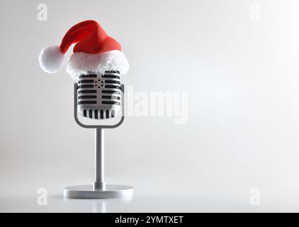 Microphone rétro en métal avec support et chapeau de Père Noël sur le dessus sur table blanche et fond isolé blanc. Vue de face. Banque D'Images