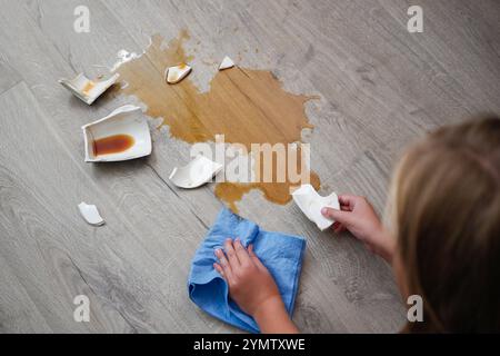 Une tasse de café cassée est tombée sur le stratifié, du café s'est renversé sur le sol. Banque D'Images