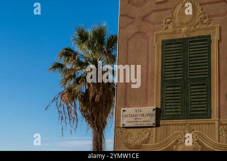 Panneau de rue sur la façade vintage avec belle vue panoramique sur la ville de Gênes, de la terrasse de Castelletto en arrière-plan. Gênes, Italie 09.01.2024 Banque D'Images