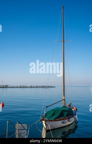 Beau voilier avec quai 'Molo audace' le long des rives de Trieste s'étendant dans la mer en arrière-plan. Piazza Unità d'Italia. Banque D'Images