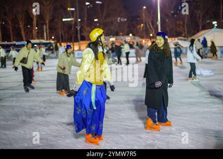 Les gens patinent la nuit sur la piste de patinage temporaire devant l'hôtel de ville de Séoul, Corée du Sud, le 9 février 2024 Banque D'Images