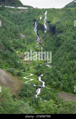 Cascade de Mardalsfossen qui coule vers la rivière Myrdola près de Myrdal, dans la municipalité d'Aurland et une route en zigzag qui longe la rampe verticale Banque D'Images