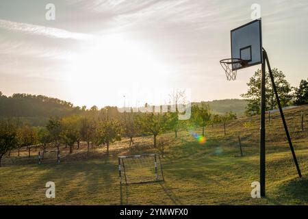 Terrain de sport dans une prairie au coucher du soleil avec une montagne à l'horizon Banque D'Images