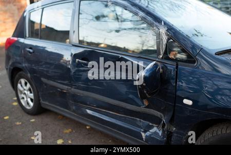 Voiture bleue endommagée avec des bosses et des rayures sur le côté, gros plan Banque D'Images