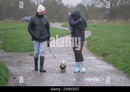 Londres, Royaume-Uni. 23 novembre 2024 les marcheurs de Wimbledon Common, au sud-ouest de Londres, brassent les conditions humides et venteuses alors que la tempête Bert frappe le Royaume-Uni. Le bureau met a placé des avertissements météorologiques pour le vent, la pluie et la neige à travers certaines parties du Royaume-Uni avec des rafales de vent atteignant 70mph crédit . Amer Ghazzal/Alamy Live News Banque D'Images