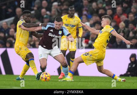 John McGinn d'Aston Villa (au centre) affronte Marc Guehi de Crystal Palace (à gauche) et Justin Devenny lors du premier League match à Villa Park, Birmingham. Date de la photo : samedi 23 novembre 2024. Banque D'Images