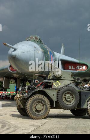 Vintage, histoire militaire préservée historique exposée. Ancien bombardier Avro Vulcan XL426 de la Royal Air Force et voiture blindée Ferret de l'armée britannique Banque D'Images