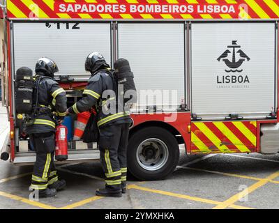 Lisbonne, Portugal - 9 juin 2024 : équipe de pompiers prenant des extincteurs de la machine de pompiers dans la rue pour éteindre un incendie Banque D'Images