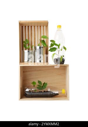 Concept de recyclage. Caisses en bois avec des plantes en bouteilles et canettes isolées sur blanc Banque D'Images