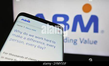 Stuttgart, Allemagne, 03-13-2024 : smartphone avec la page Web de la société américaine de gestion des installations ABM Industries Inc devant le logo de l'entreprise. Concentrez-vous sur les Banque D'Images