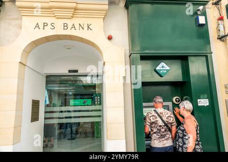 Valletta Malta, Republic Street, APS Bank, entrée extérieure, couple senior homme femme, en utilisant ATM, Maltese Europe européenne UE, les visiteurs voyagent traveli Banque D'Images