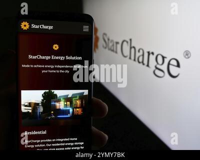Stuttgart, Allemagne, 07-14-2024 : personne tenant un téléphone portable avec la page web de la compagnie singapourienne de recharge de véhicule électrique Star charge avec le logo. Focus o o Banque D'Images