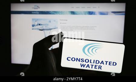 Stuttgart, Allemagne, 06-26-2024, une personne tenant un smartphone avec le logo de la société de dessalement de l'eau de mer Consolidated Water Co. Ltd devant le site Web. Banque D'Images