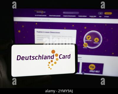 Stuttgart, Allemagne, 07-15-07 2024 : personne tenant un smartphone avec le logo de la société allemande de fidélisation de la clientèle DeutschlandCard GmbH devant le site Web. Mise au point Banque D'Images