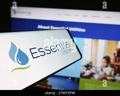 Stuttgart, Allemagne, 07-06-2024 : smartphone avec le logo de la société américaine Essential Utilities Inc devant le site. Concentrez-vous sur Center-L. Banque D'Images