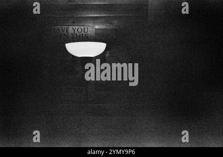 Une image montrant une photo en noir et blanc d'une lampe dans une pièce faiblement éclairée, créant une atmosphère mystérieuse et sombre Banque D'Images