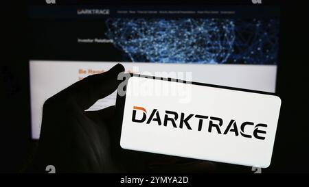 Stuttgart, Allemagne, 03-17-03 2024 : personne tenant un smartphone avec le logo de la société britannique de cybersécurité Darktrace plc devant le site web. Concentrez-vous sur le phon Banque D'Images