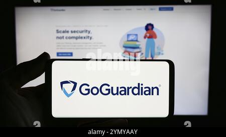 Stuttgart, Allemagne, 03-05-2024 : personne tenant un smartphone avec le logo de la société américaine de logiciels éducatifs Liminex Inc (GoGuardian) devant le site. Banque D'Images