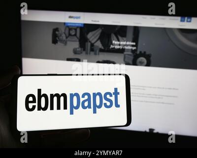 Stuttgart, Allemagne, 04-13-2024 : personne tenant un smartphone avec le logo de la société allemande de moteurs électriques EBM-Papst Gruppe devant le site web. Concentrez-vous sur le ph Banque D'Images