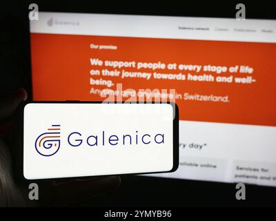 Stuttgart, Allemagne, 05-31-2024, personne tenant un smartphone avec le logo de la société pharmaceutique suisse Galenica AG devant le site web. Concentrez-vous sur le téléphone d Banque D'Images