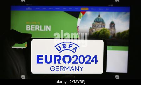 Stuttgart, Allemagne, 05-16-05 2024 : personne tenant un téléphone portable avec le logo du championnat d'Europe de football UEFA Euro 2024 devant la page web. Concentrez-vous sur le phon Banque D'Images