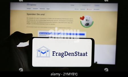 Stuttgart, Allemagne, 05-21-05 2024 : personne tenant un téléphone portable avec le logo de l'organisation non gouvernementale allemande FragDenStaat devant la page web. Concentrez-vous sur Banque D'Images