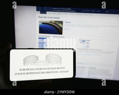 Stuttgart, Allemagne, 05-21-05 2024 : personne tenant un smartphone avec le logo de la Cour européenne des droits de l'homme (CEDH) devant le site web. Banque D'Images