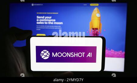 Stuttgart, Allemagne, 07-11-2024 : personne tenant un téléphone portable avec le logo de la société de commerce électronique américaine Moonshot ai Inc en face de la page Web de l'entreprise. Concentrez-vous sur le ph Banque D'Images