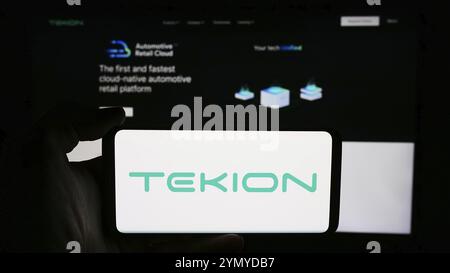 Stuttgart, Allemagne, 06-01-2024 : personne tenant un téléphone portable avec le logo de la société américaine de technologie cloud Tekion Corp. en face de la page Web de l'entreprise. Concentrez-vous sur Banque D'Images