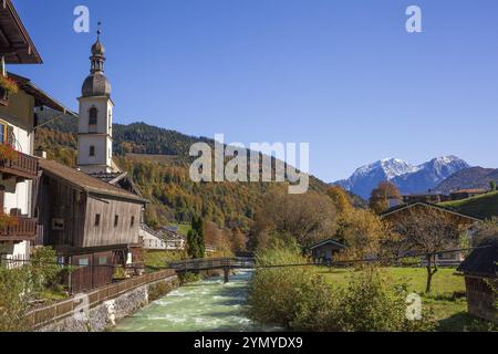 Église paroissiale de Sebastian en automne avec la rivière Ramsauer Ache, derrière les montagnes de la Reiteralpe, Ramsau, Berchtesgaden, Berchtesgadener Land Banque D'Images