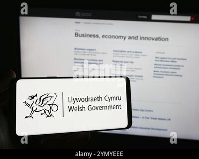 Stuttgart, Allemagne, 03-25-2024, personne tenant un smartphone avec le logo du gouvernement gallois (Llywodraeth Cymru) devant le site. Concentrez-vous sur le téléphone Banque D'Images