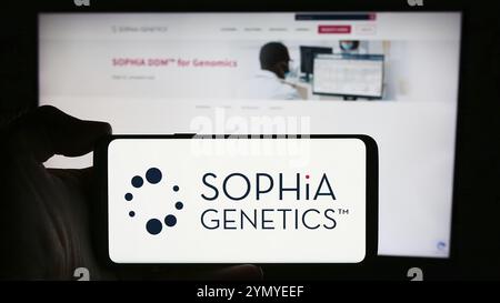 Stuttgart, Allemagne, 04-10-2024 : personne tenant un téléphone portable avec le logo de la société suisse de logiciels de santé Sophia Genetics sa en face de la page web de l'entreprise. F Banque D'Images