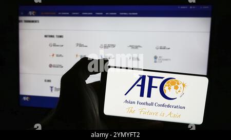Stuttgart, Allemagne, 06-25-2024, personne tenant un téléphone portable avec le logo de l'association Confédération asiatique de football (AFC) devant la page web. Concentrez-vous sur Banque D'Images