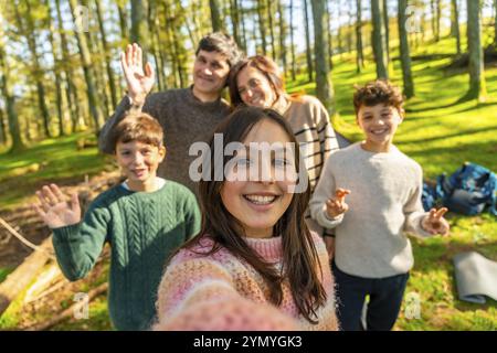 Famille caucasienne prenant selfie dans une forêt alpine profitant de la nature ensemble dans une journée ensoleillée Banque D'Images