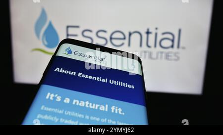 Stuttgart, Allemagne, 07-06-2024 : téléphone portable avec la page Web de la société américaine Essential Utilities Inc devant le logo de l'entreprise. Concentrez-vous sur le dessus Banque D'Images
