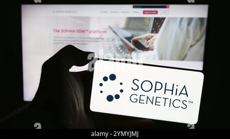 Stuttgart, Allemagne, 04-10-2024 : personne tenant un smartphone avec le logo de la société suisse de logiciels de santé Sophia Genetics sa en face du site web. Concentrez-vous sur Banque D'Images