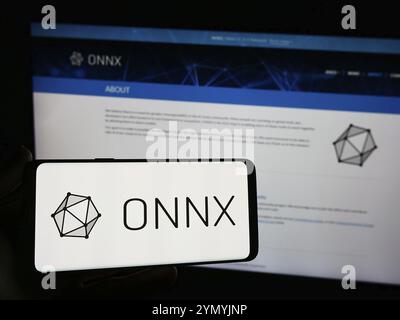Stuttgart, Allemagne, 03-13-03 2024 : personne tenant un smartphone avec le logo de l'ai Ecosystem Open Neural Network Exchange (ONNX) devant le site web. Concentrez-vous sur Banque D'Images
