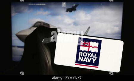 Stuttgart, Allemagne, 03-25-2024, personne tenant un smartphone avec le logo de la Royal Navy (RN) de guerre navale du Royaume-Uni devant le site web. Concentrez-vous sur le phon Banque D'Images