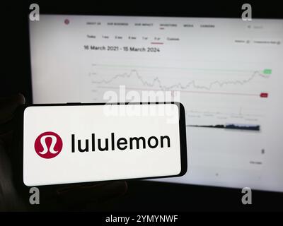 Stuttgart, Allemagne, 03-16-03 2024 : personne tenant un téléphone portable avec le logo de la société canadienne de vente au détail de vêtements Lululemon Athletica Inc. devant la page Web Banque D'Images