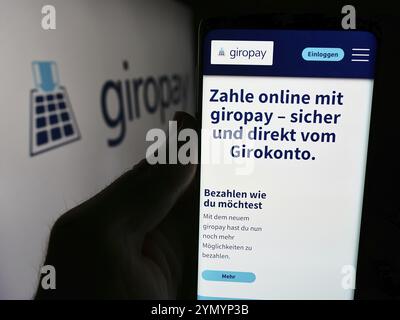 Stuttgart, Allemagne, 07-04-2024 : personne tenant un téléphone portable avec la page web de la société de paiement allemande Giropay (Paydirekt GmbH) devant le logo. Concentrez-vous sur c Banque D'Images