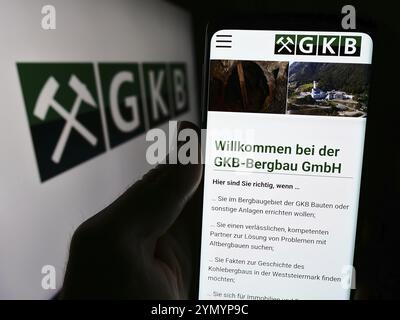 Stuttgart, Allemagne, 04-07-2024 : personne tenant un smartphone avec le site web de la société autrichienne GKB Bergbau GmbH devant le logo. Concentrez-vous sur le centre du téléphone Banque D'Images