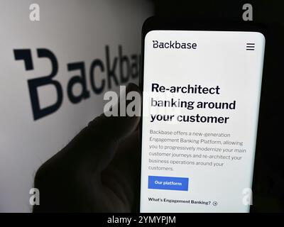 Stuttgart, Allemagne, 07-11-2024 : personne tenant un smartphone avec la page web de la société néerlandaise de fintech Backbase B.V. devant le logo de l'entreprise. Concentrez-vous sur cent Banque D'Images