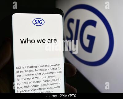 Stuttgart, Allemagne, 05-31-2024, personne tenant un smartphone avec la page web de la société suisse d'emballage SIG Group AG devant le logo de l'entreprise. Focus sur le cen Banque D'Images