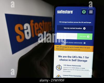 Stuttgart, Allemagne, 04-07-2024 : personne tenant un smartphone avec la page web de la société britannique de self-stockage Safestore Holdings plc devant le logo. Mise au point Banque D'Images