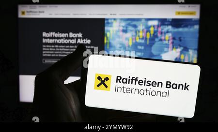 Stuttgart, Allemagne, 03-16-03 2024 : personne tenant un smartphone avec le logo de la société autrichienne Raiffeisen Bank International AG (RBI) devant le site. FO Banque D'Images