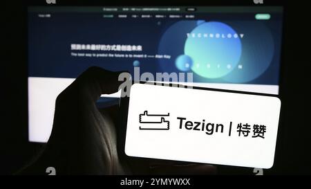 Stuttgart, Allemagne, 05-15-05 2024 : personne tenant un téléphone portable avec le logo de la société chinoise d'analyse de contenu Tezign devant la page Web de l'entreprise. Mise au point Banque D'Images