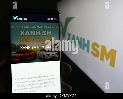 Stuttgart, Allemagne, 04-17-2024 : personne tenant un téléphone portable avec la page web de la société de mobilité vietnamienne Xanh SM devant le logo de l'entreprise. Concentrez-vous sur cente Banque D'Images